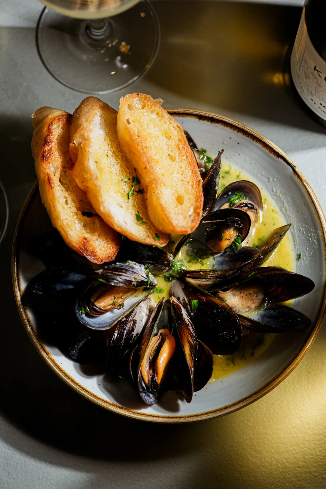 A bowl of Saldanha Bay mussels in a creamy sauce with toasted bread