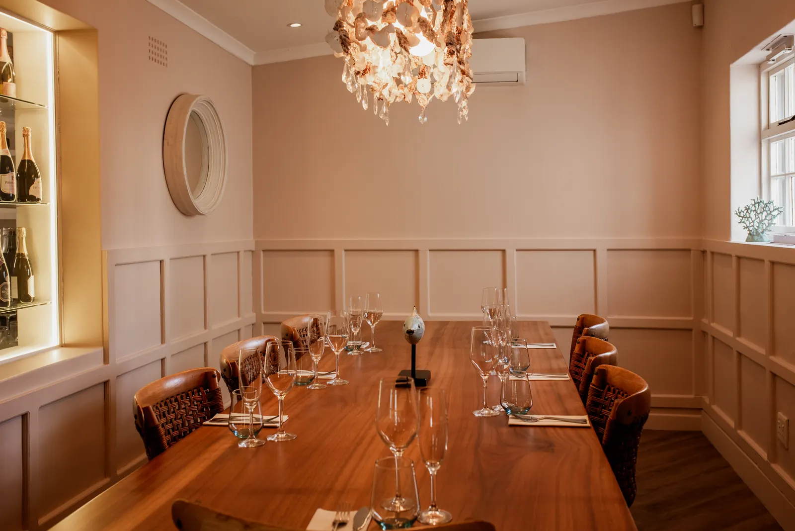 The private dining room with a long table under a statement chandelier